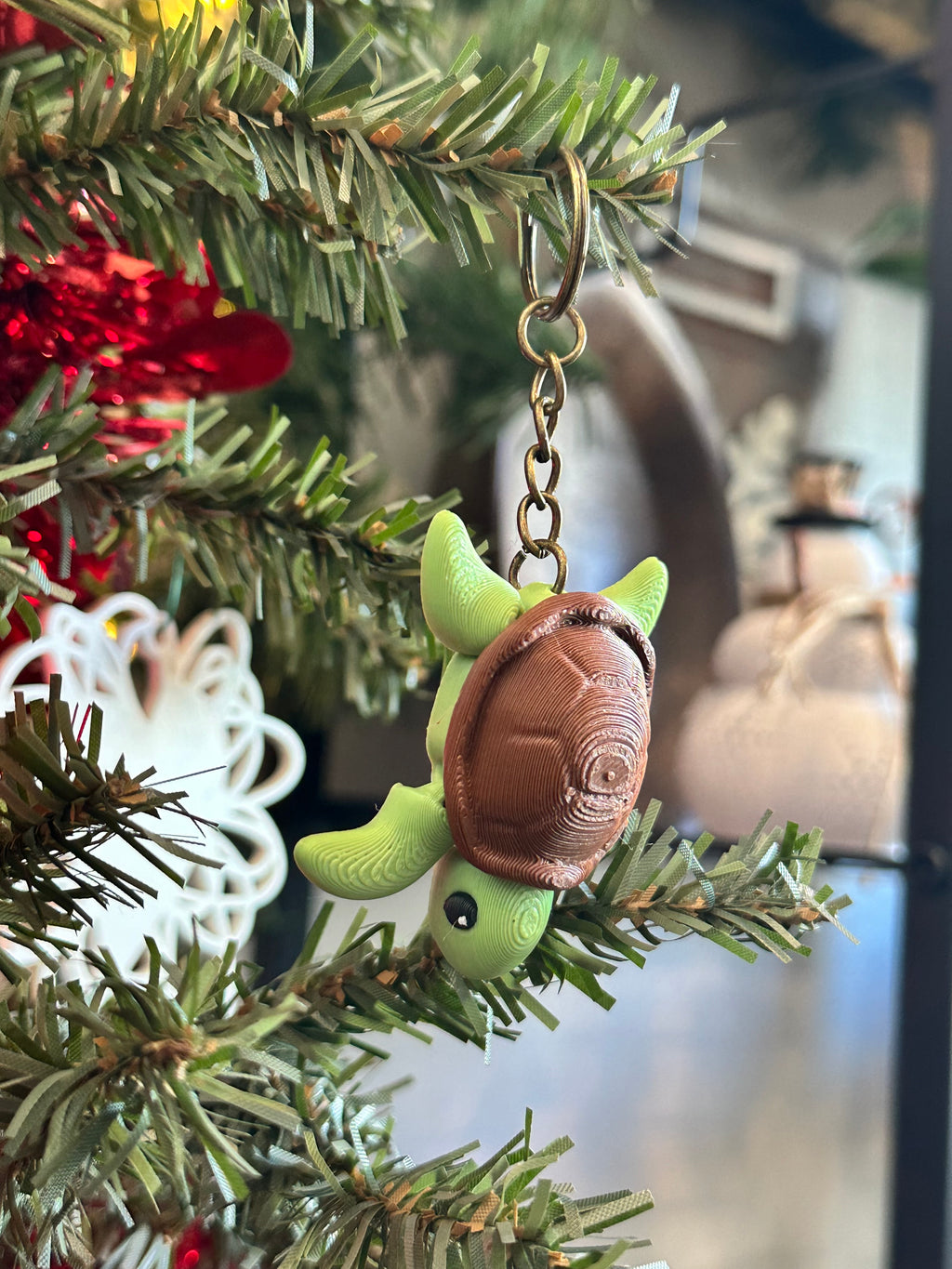 Decorative turtle ornament on a Christmas tree with blurred background