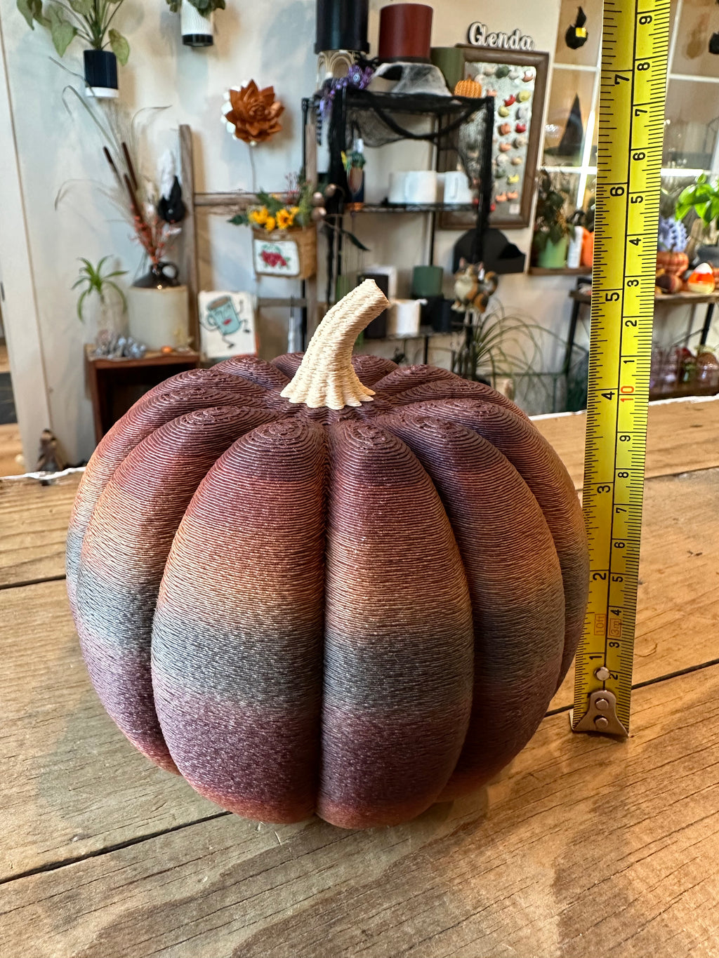 Large multicolor 3D printed decorative pumpkin photographed beside a measuring tape for size reference.