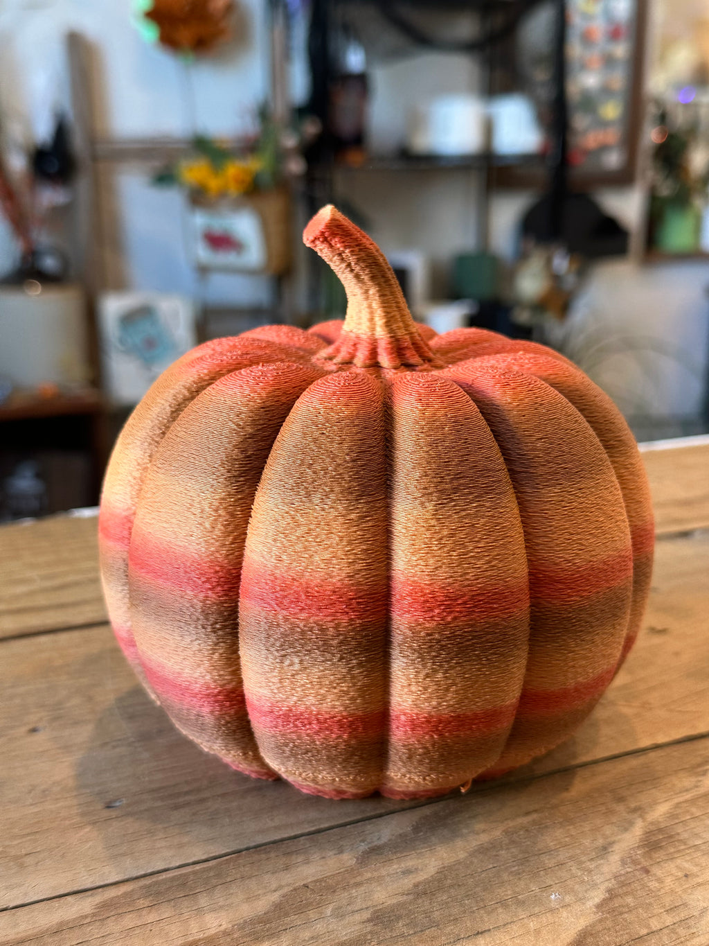 Close-up of a large orange and brown 3D printed pumpkin showing deep ridges and layered texture.